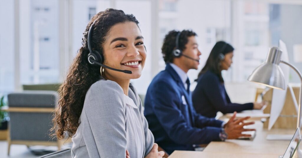 Agent smiling while using a call center dialer to make outbound calls.