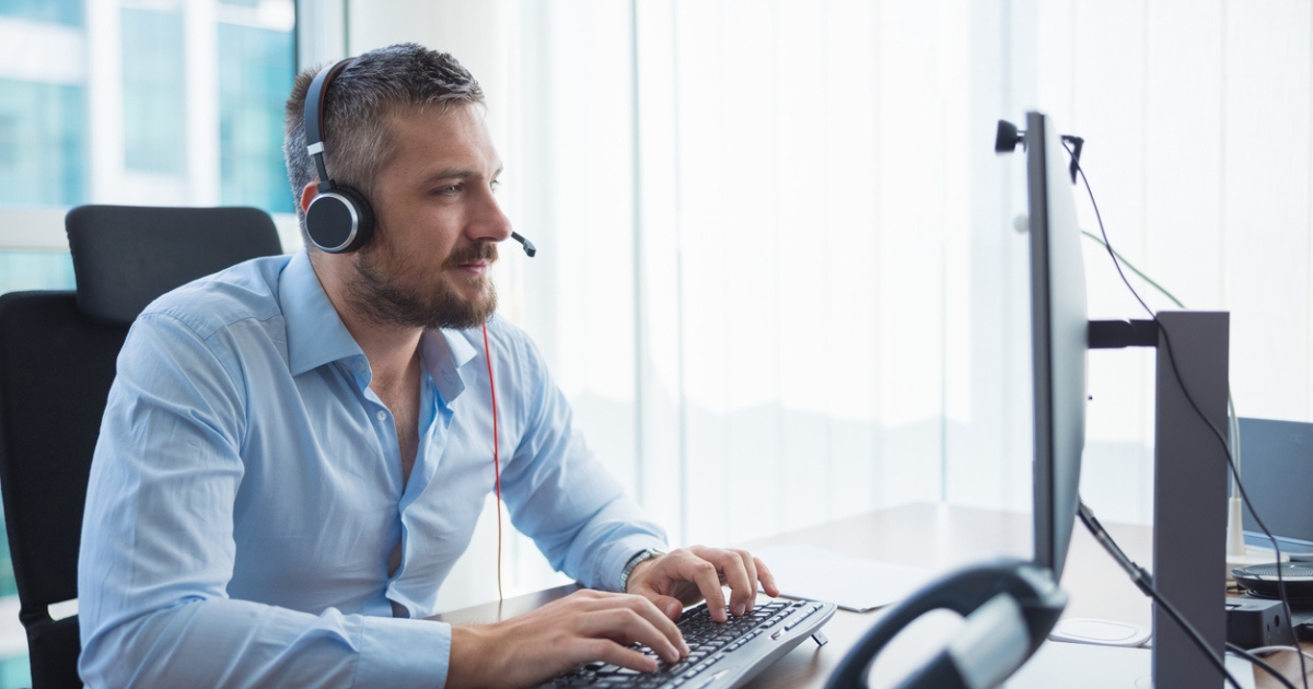 A call center agent making a call on their laptop using a predictive dialer.